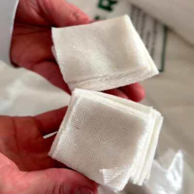 Odontólogo sosteniendo una gasa trozada de algodón de 10x10 cm.
