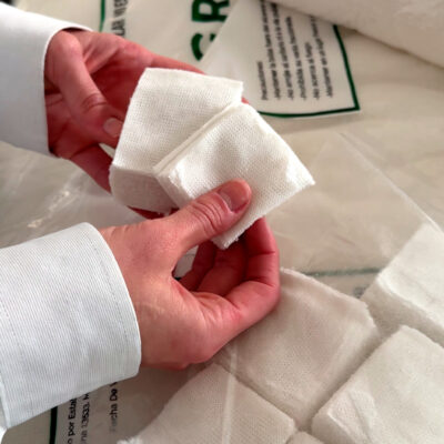 Manos de un odontólogo sosteniendo un pequeño fajo de gasas de 10x10 cm.